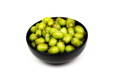 Beyaz arka planda izole edilmiş siyah seramik kasede taze Neem meyvesi. Neem meyvesi mükemmel bir nemlendiricidir ve böcek öldürücü ve tıbbi özellikleri olan çeşitli bileşikler içerir..