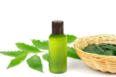 Plastik şişedeki Neem Şampuanı ve beyaz arka planda izole edilmiş taze neem yaprağı. Saç ve kafa derisi kavramını önemseyen doğal ürünler.