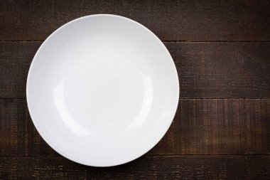 Beyaz boş tahta arka plan, Üst Manzara. Seramikten yapılmış bir tabak. Enfes sofra takımı.