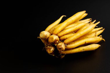 Taze parmak kökü (Krachai) siyah arkaplanda izole edildi. Bilimsel adı Boesenbergia rotunda. Parmak kökü bitki ve Tayland yemeği malzemesidir..