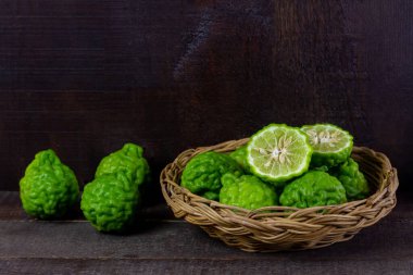 Tahta masada hasır sepetin içinde Bergamot meyvesi. Bergamot Asya yemeklerinde kullanılan bir maddedir ve vücut bakımı için bir bitkidir..