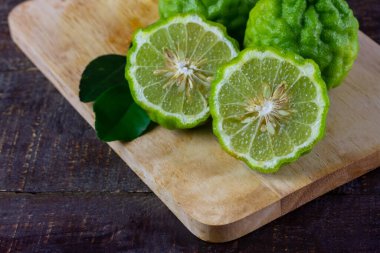 Tahta üzerinde tahta kesme tahtası üzerinde Bergamot meyvesi. Bergamot Asya yemeklerinde kullanılan bir maddedir ve vücut bakımı için bir bitkidir..