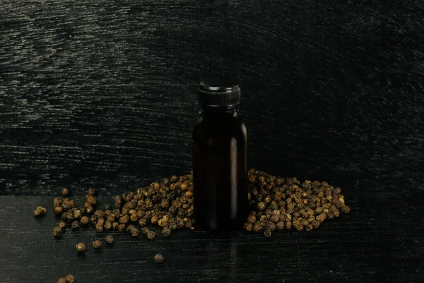 Black Pepper Essential Oil Glass Bottle Peppercorn Black Wooden Background — Stock Photo, Image