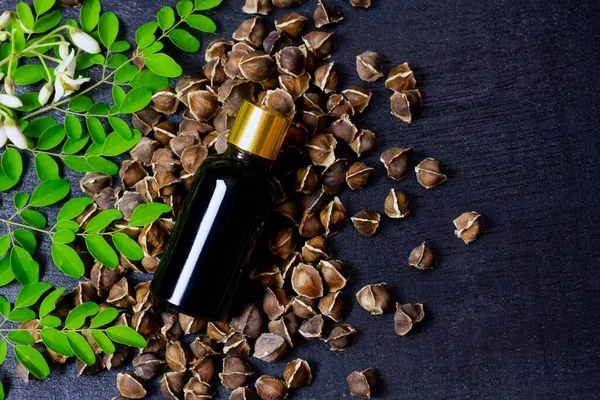Minyak Moringa Dalam Botol Dengan Daun Hijau Bunga Dan Biji — Stok Foto