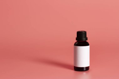 Pembe arkaplan üzerinde boş etiket maketi olan şişe.