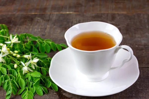 莫林加茶 白色陶瓷杯 绿叶鲜绿 木制底色花朵 Moringa Oleifera热带草本植物健康生活方式概念 — 图库照片