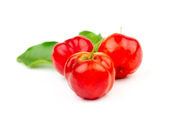 Beyaz arkaplanda yeşil yapraklı Acerola Cherry veya Barbados Cherry.