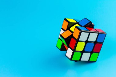SAMUT-SAKHON, THAILAND - 13 Nisan 2022: Rubik küp bulmacası mavi arkaplanda izole edilmiş,.