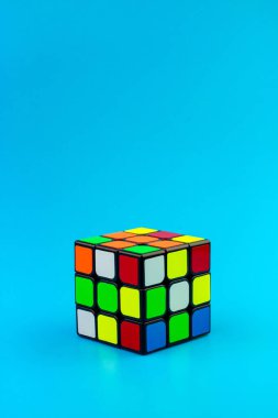 SAMUT-SAKHON, THAILAND - 13 Nisan 2022: Rubik küp bulmacası mavi arkaplanda izole edilmiş,.