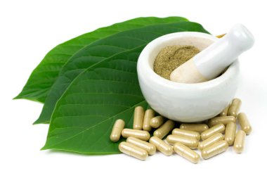 Mitragyna Speciosa Korth veya kratom kapsülleri beyaz arkaplanda izole edilmiş havan ve kabuk ve yeşil yaprak ile. 