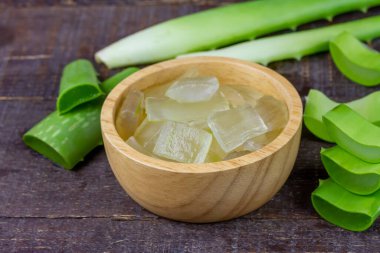 Aloe Vera jeli ahşap kasede, ahşap arka planda taze aloe vera ile.