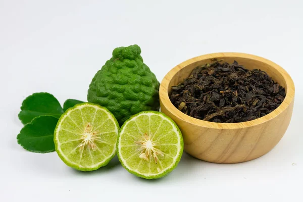 Bergamot tea or Earl Grey tea in wooden bowl and fresh bergamot fruit isolated on white background.