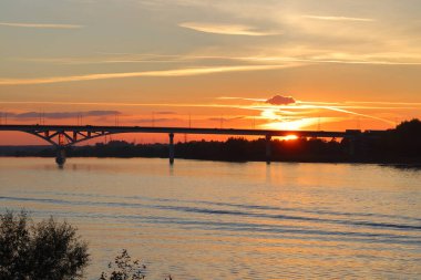 Volga üzerinde gün batımına karşı köprü, nehirde dalgalar, bulutlar, parlak ve renkli arka plan, Moskova bölgesi, Eylül 2021