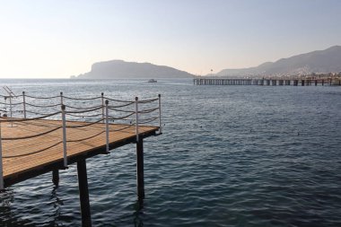 Alanya sahillerinde rıhtımlar, arka planda dağlar, Türkiye, Kasım 2021.