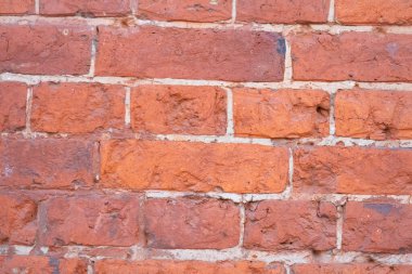 Kırmızı tuğla duvar, hafif beton tabakası, düzensiz ve aşınmış tuğla yüzeyi, parlak kırmızı zemin