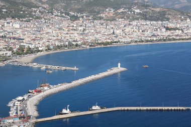 Konut binaları ve dağların arka planında gemi ve rıhtım, güzel Akdeniz arka planı, Alanya Kasım 2021.