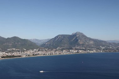 Yeşil dağların eteklerindeki kentsel gelişim ve mavi Monet, Alanya, Kasım 2021.