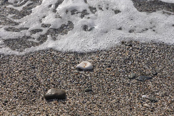 Islak Deniz Kumlarında Pürüzsüz Taşlar Dalga Plaj Arka Planında — Stok fotoğraf