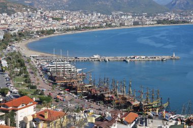 Alanya limanında, Türkiye 'de Kasım 2021' de bir rıhtım ve kentsel kalkınmanın arka planına karşı tekneler.