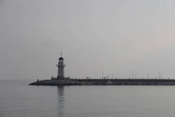 在平静的大海背景下 在阴天里 灯塔和码头的轮廓 阿拉亚 2021年11月 — 图库照片