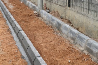 Yaya yolu inşaatı, kaldırım taşı ve tur bindirilmiş toprak, inşaat arka planı.
