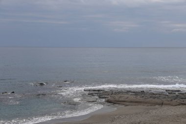 Bulutlu bir günde Alanya sahilindeki düz kayalar, minimalizm, Türkiye, Aralık 2021.