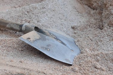 İnşaat işçisi küreği kumda, inşaat aletinde, inşaat geçmişinde yatıyor..