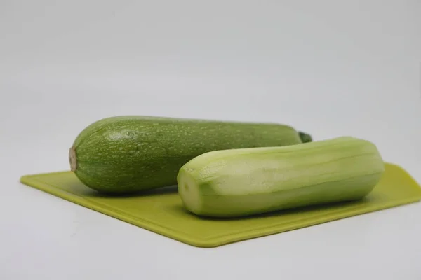 One Peeled One Unpeeled Green Courgette Zucchini Cutting Kitchen Board — Stockfoto