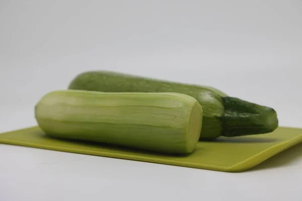 One Peeled One Unpeeled Green Courgette Zucchini Cutting Kitchen Board — Foto Stock