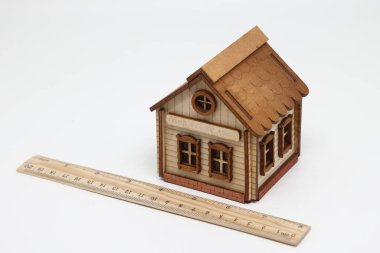 Tahta cetvel ve oyuncak evi banknotların, gayrimenkul değerlendirmelerinin yanında yer alır..