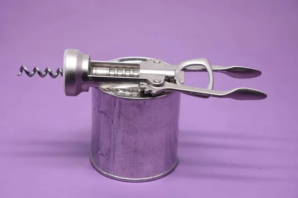 把各种金属和白色的锡子放在紫色的背景上 金属罐开启器 — 图库照片