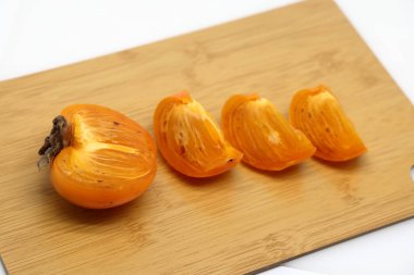 fresh ripe sweet persimmon on white plate, delicacy.