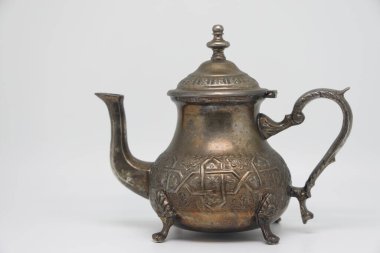 Antique metal teapot on a white background. Close-up of an old Arabic teapot
