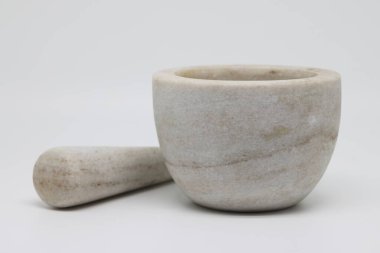 Stone mortar with pestle on a white background, kitchen utensils, light stone