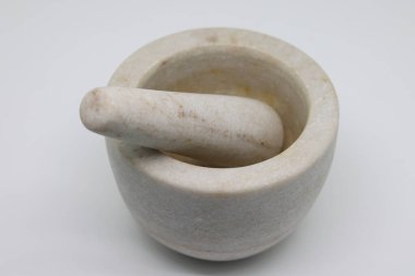 Stone mortar with pestle on a white background, kitchen utensils, light stone