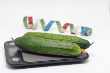 Cucumbers on the scales. Weight loss, diet and weight control. Still life with healthy food and scales. Healthy food. The concept of a healthy lifestyle. Weight control during lockdown