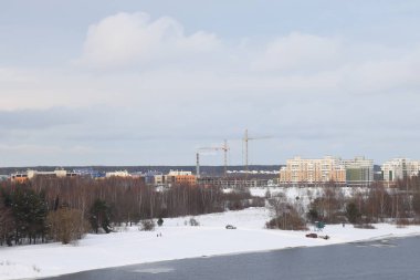 Güneşli bir akşamda nehir. Ağaçlar ve çalılar. Kış manzarası, nehir kıyıları çalılarla kaplı.
