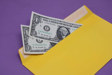 Banknotlar mor arka planda sarı bir zarfın içinde. Rüşvet konsepti. Maaşlar zarflarda. Finansal dolandırıcılık. Kapat.