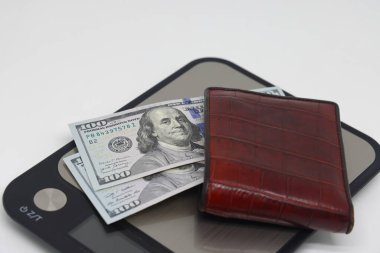 Elektronik mutfak terazilerindeki banknotların olduğu kahverengi cüzdan. Muhasebe ve aile finansmanı planlama sembolü