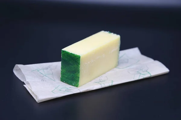 Ein Stück Käse Auf Pergamentpapier Auf Dunklem Hintergrund Gesunde Ernährung — Stockfoto