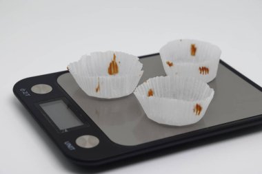 Pastalar için kağıt soketler. Elektronik mutfak terazilerindeki kekler. Sağlıksız yiyecekler. Sağlıklı yaşam tarzı kavramı. diyet ihlali. Ağırlık denetimi