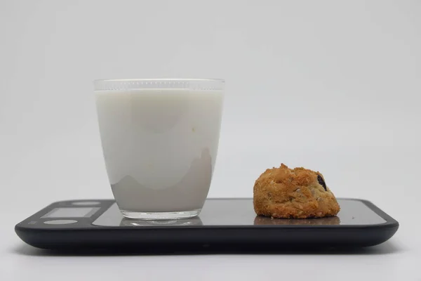キッチンスケールで自家製クッキーとガラスカップ ダイエットとカロリーカウント 暗い背景 — ストック写真