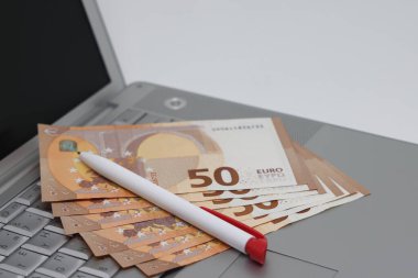 Banknotlar ve gözlükler dizüstü bilgisayarın klavyesinde yatıyor, serbest kazançlar