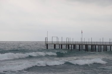Köpük dalgalarının önünde yalnız bir şahsiyet ve Alanya 'da tarihi bir dağ, Kasım 2021