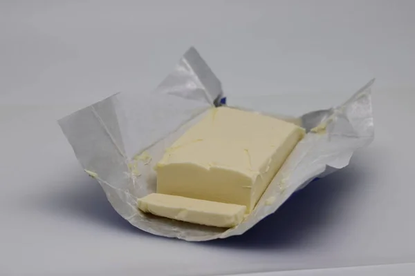 Geschnitten Block Frischer Butter Mit Wrap Auf Weißem Hintergrund — Stockfoto