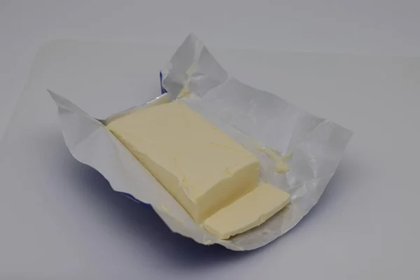 Geschnitten Block Frischer Butter Mit Wrap Auf Weißem Hintergrund Stockfoto