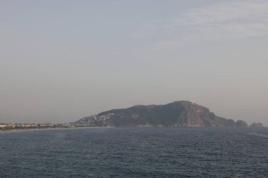 Kleopatra Sahili 'nde fırtına, tarihi dağ Alanya' nın arka planında köpük dalgaları, Kasım 2021