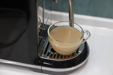 Kahve makinesi ve cam kahve fincanı, banknotlar yakınlarda, kahve ücreti, finansal tahminler