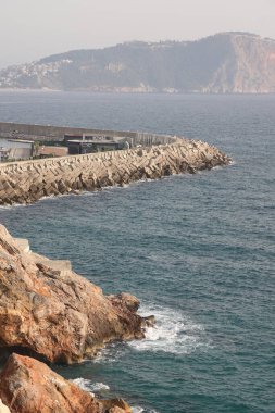 Kleopatra Sahili 'nde fırtına, tarihi dağ Alanya' nın arka planında köpük dalgaları, Kasım 2021