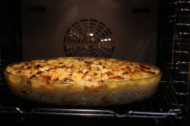 Kızarmış sebze karışımı şeffaf bir tabakta fırında pişirilir.